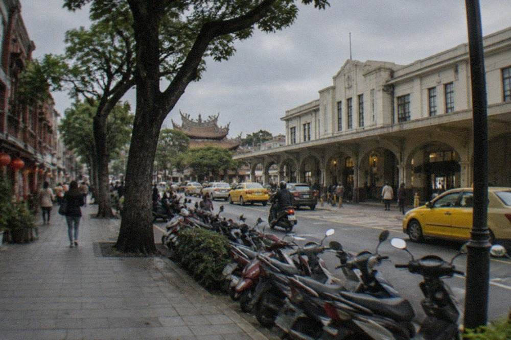 A wide paved walkway in Tainan lined with old brick buildings and shade trees