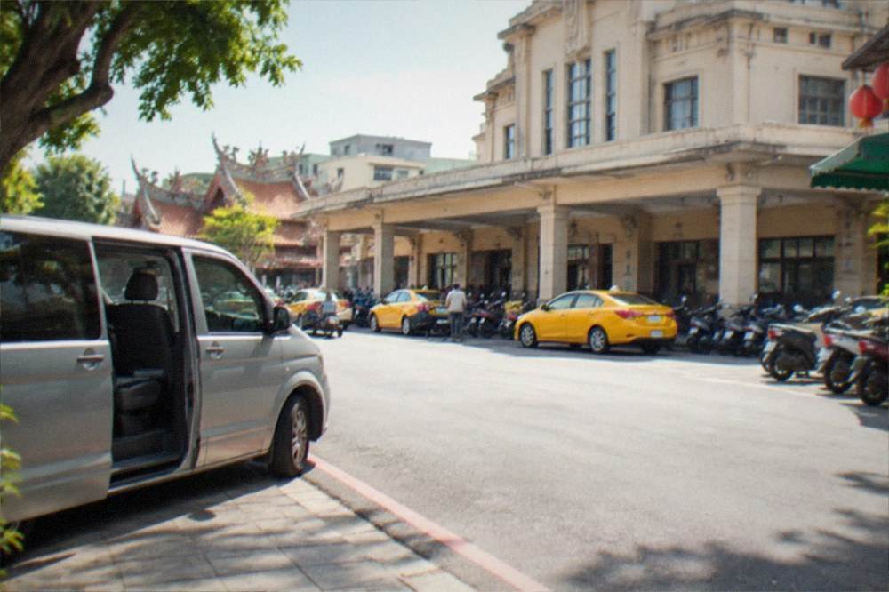 A small private tour van parked on a quiet street with its door open