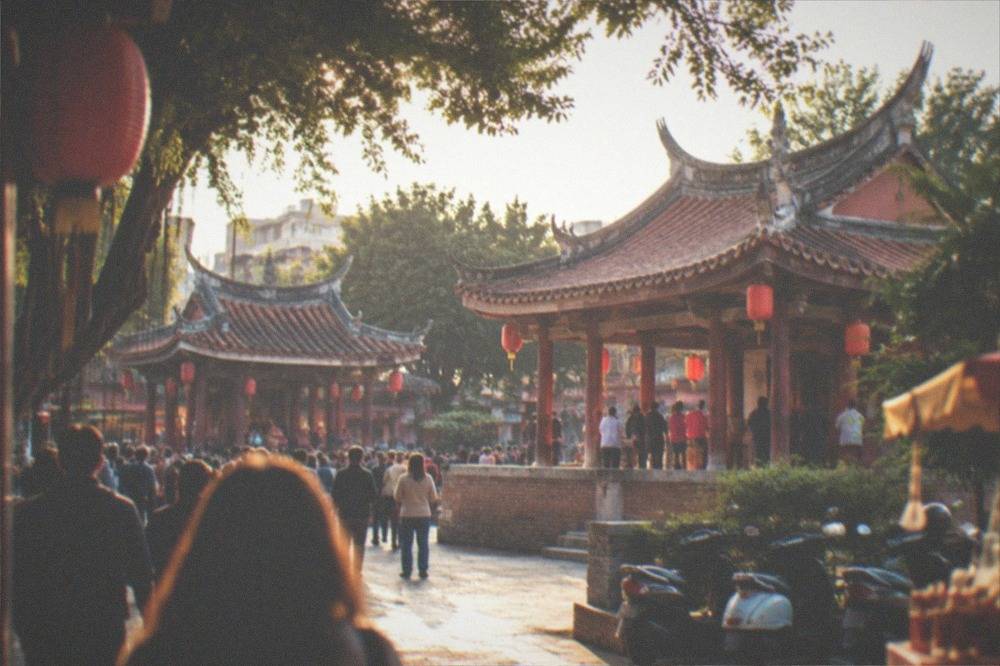 A crowded temple forecourt with red lanterns and worshippers in Tainan