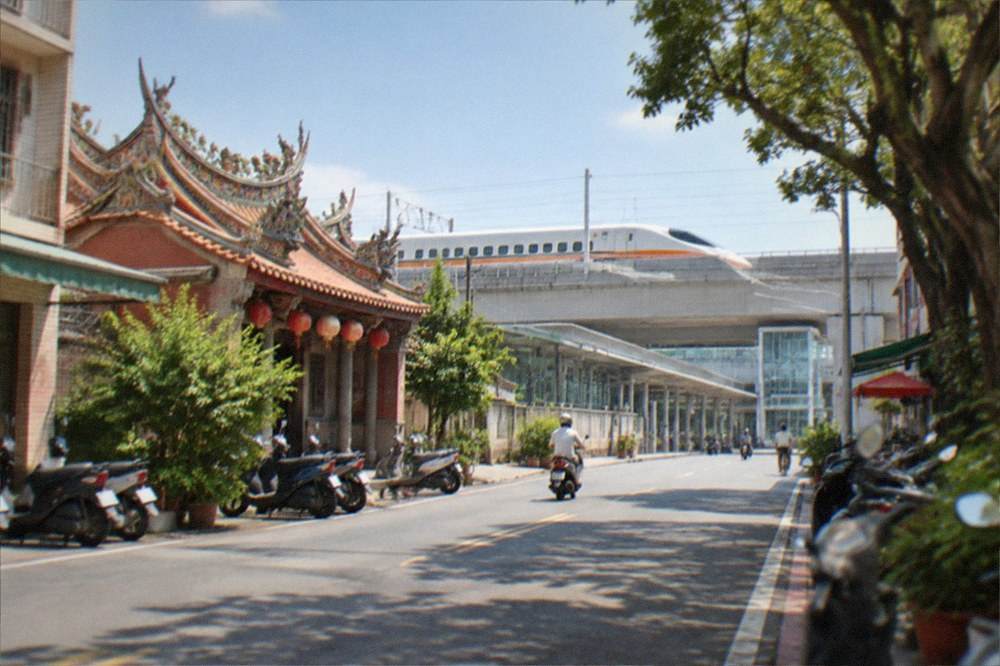A white high speed rail train pulling into a modern station platform in Taiwan