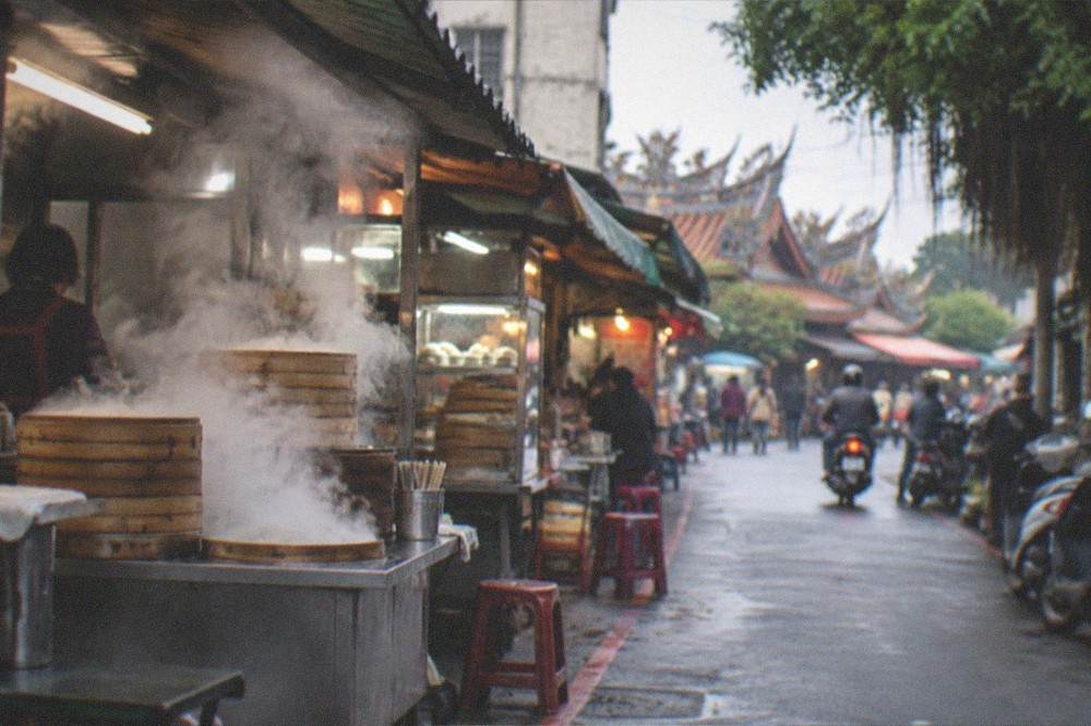 Steam rising from breakfast stalls on a Tainan street in the early morning light