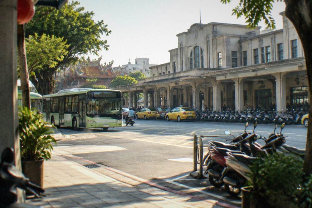 A low-floor Tainan city bus at a stop on a sunny street