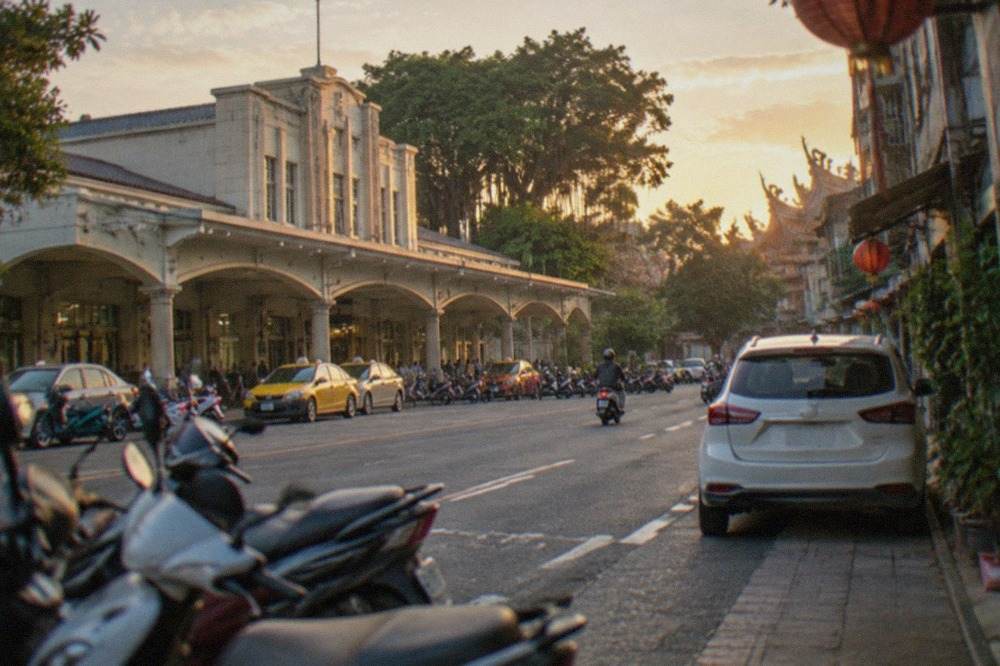 A rental car parked on a quiet street beside old low-rise buildings in central Tainan