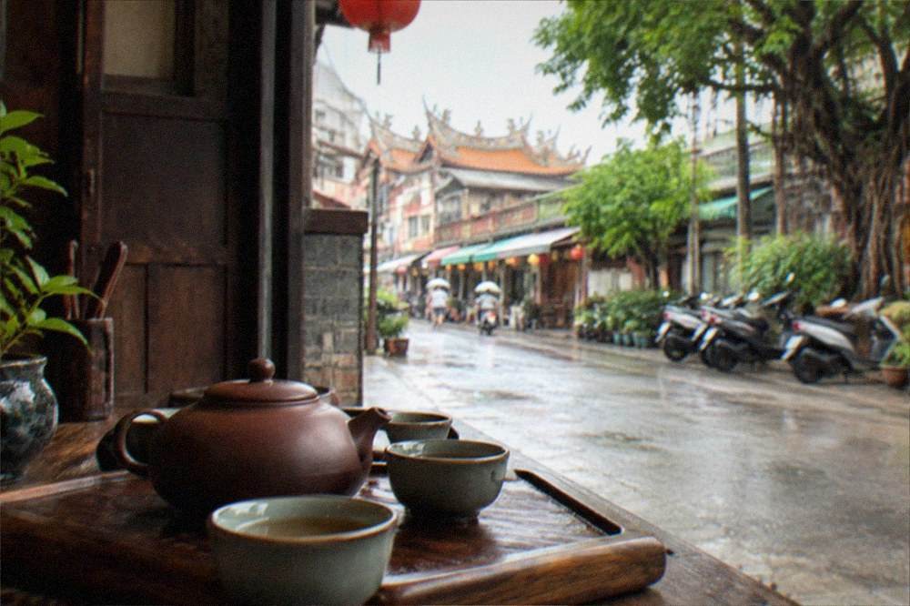 A traditional tea setting with a clay pot and small cups on a wooden tray in a restored Tainan house