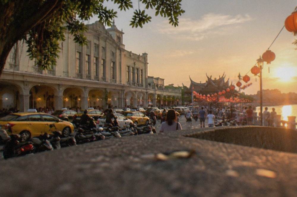 Lanterns glowing over a waterfront festival crowd in Tainan at dusk