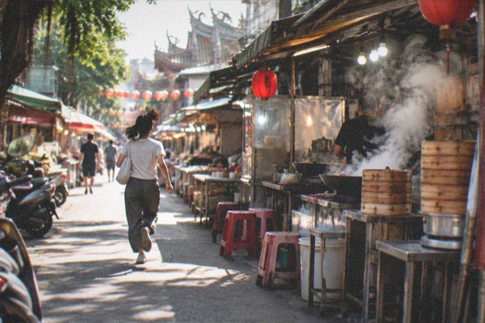 Steam rising from food stall woks in a Tainan market at night