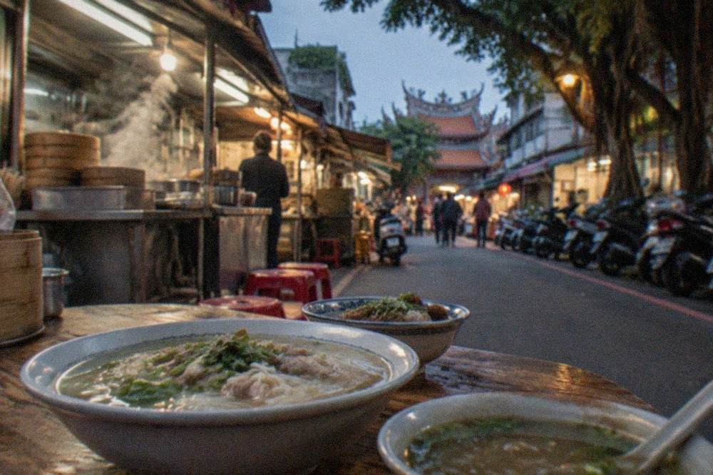 Bowls of noodles and soup arranged on a wooden table in a small Taiwanese eatery