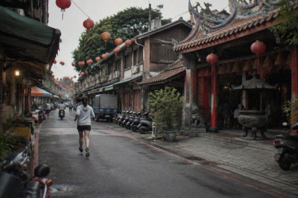 A traditional Taiwanese temple courtyard with red columns and incense coils under the eaves