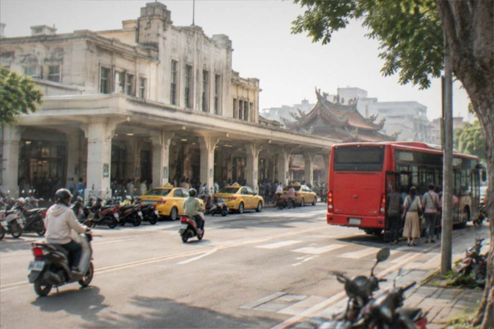 A red city bus at a stop on a Tainan street with passengers boarding