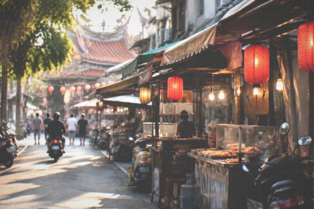 A row of food stalls with lanterns lit along a Tainan market street