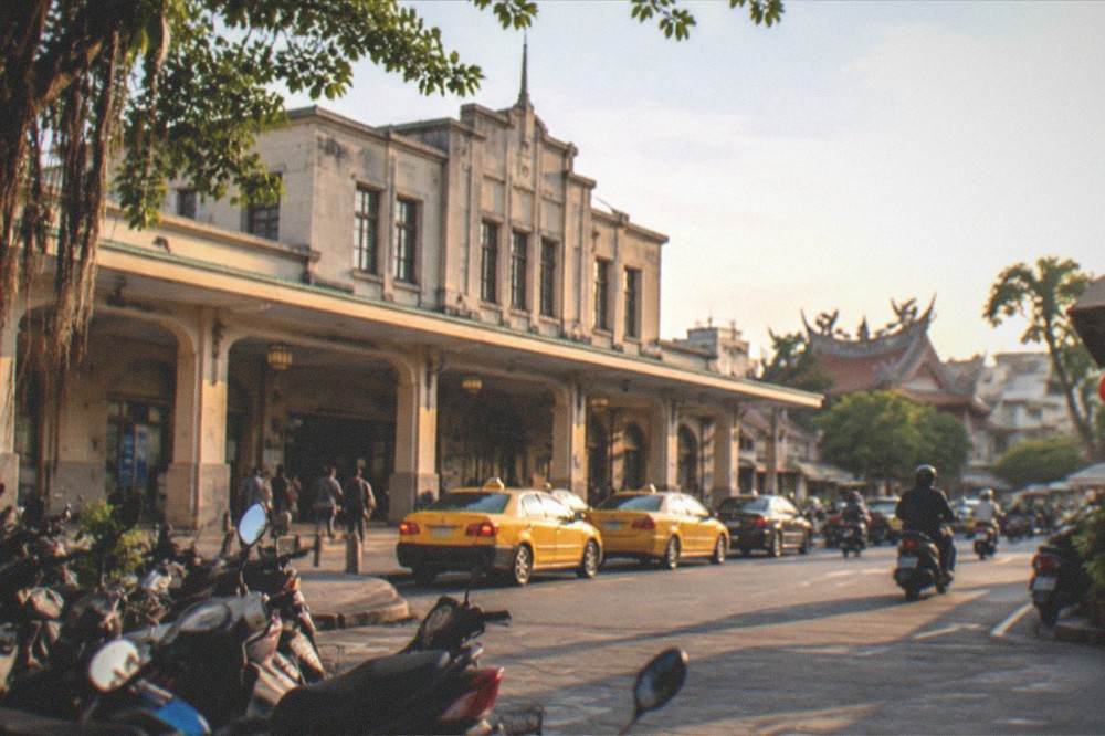 A calm Tainan canal at sunset reflecting old buildings