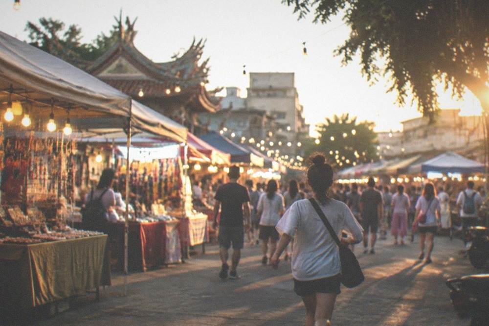 Crowded stalls with hanging lights at a Tainan night market