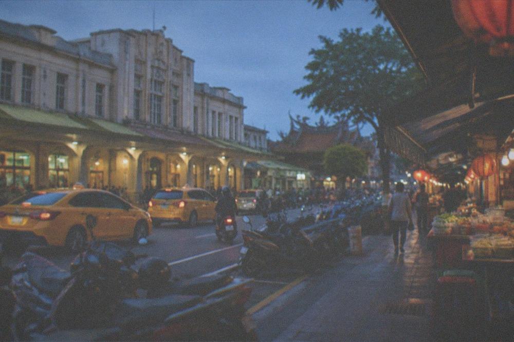 A covered alley of small food stalls glowing at night in Tainan