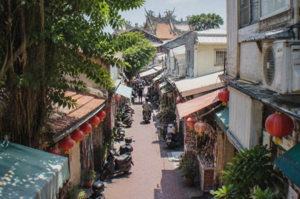 A shopping street in Tainan lined with small storefronts and hanging lanterns
