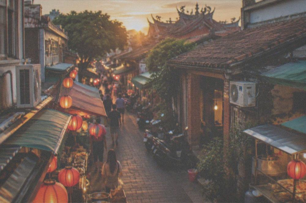 A lantern-lit Tainan night market aisle with food stalls on both sides