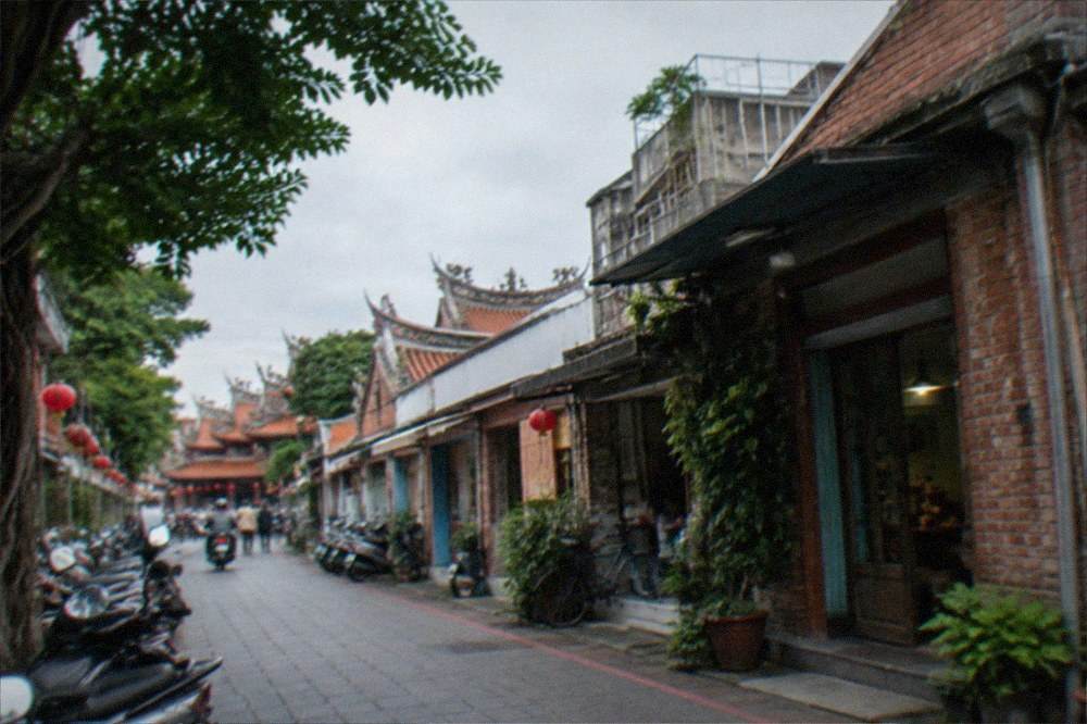A daytime lane in Anping with old brick storefronts and hanging signs