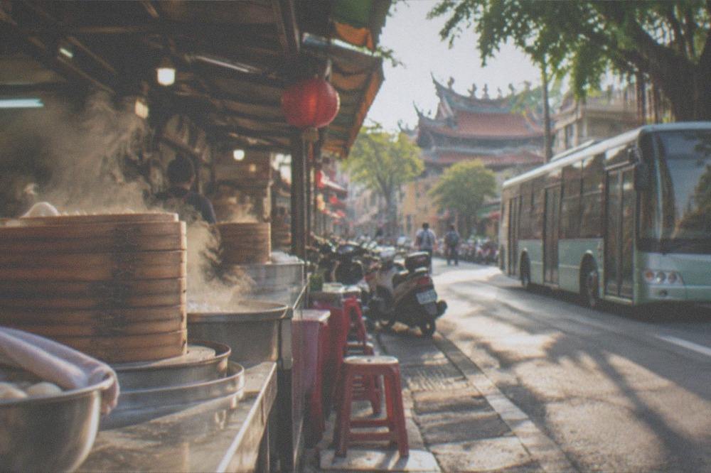 A low-floor Tainan city bus at a stop on a sunny street