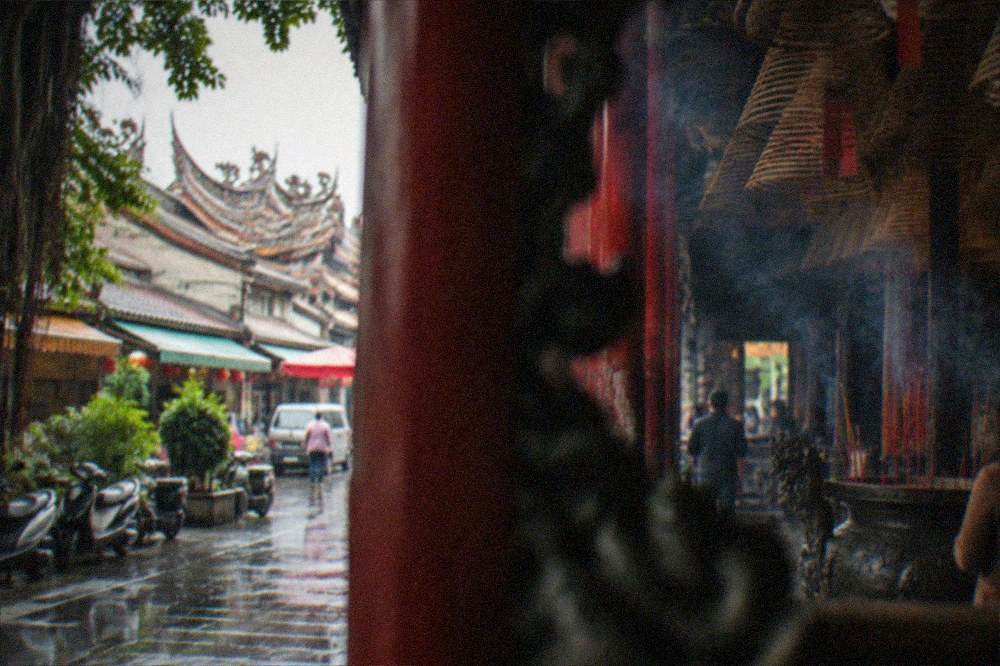 Street in Tainan old quarter with temple roofline visible above tiled shopfronts