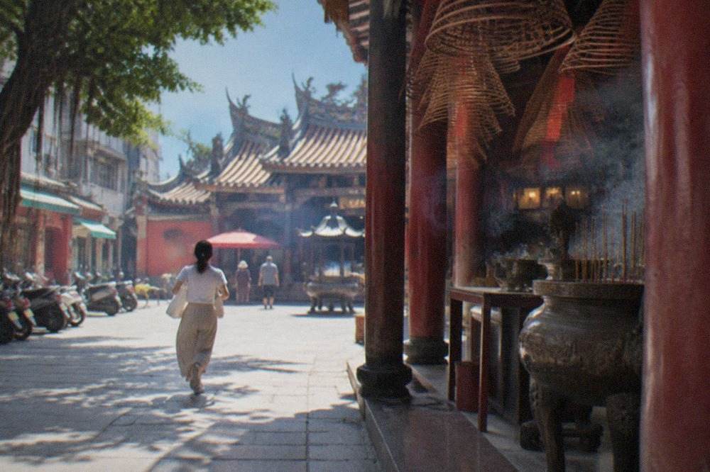 A historic Tainan temple courtyard with red walls and a tiled roof under a blue sky