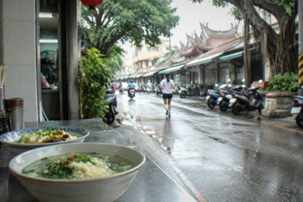 Bowls of tofu and vegetable noodle soup on a restaurant counter