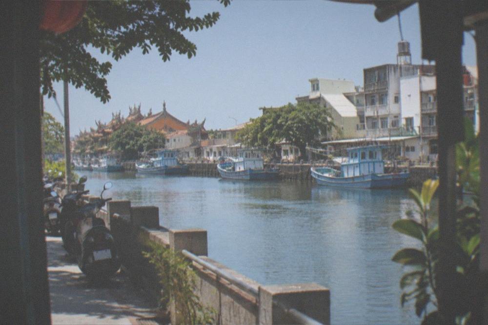 Clear autumn sky over Anping canal with boats moored along the bank
