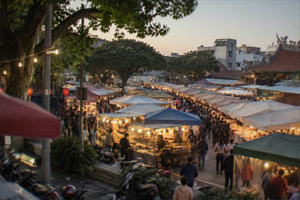 A mild winter evening at a Tainan night market with warm food stall lights
