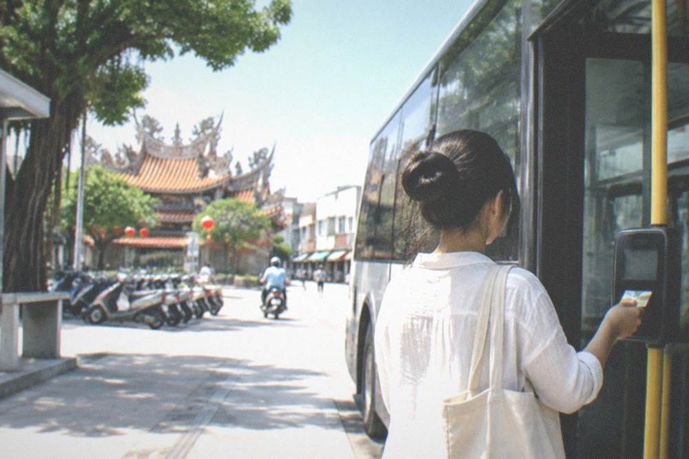 A passenger tapping a transit card on a bus card reader