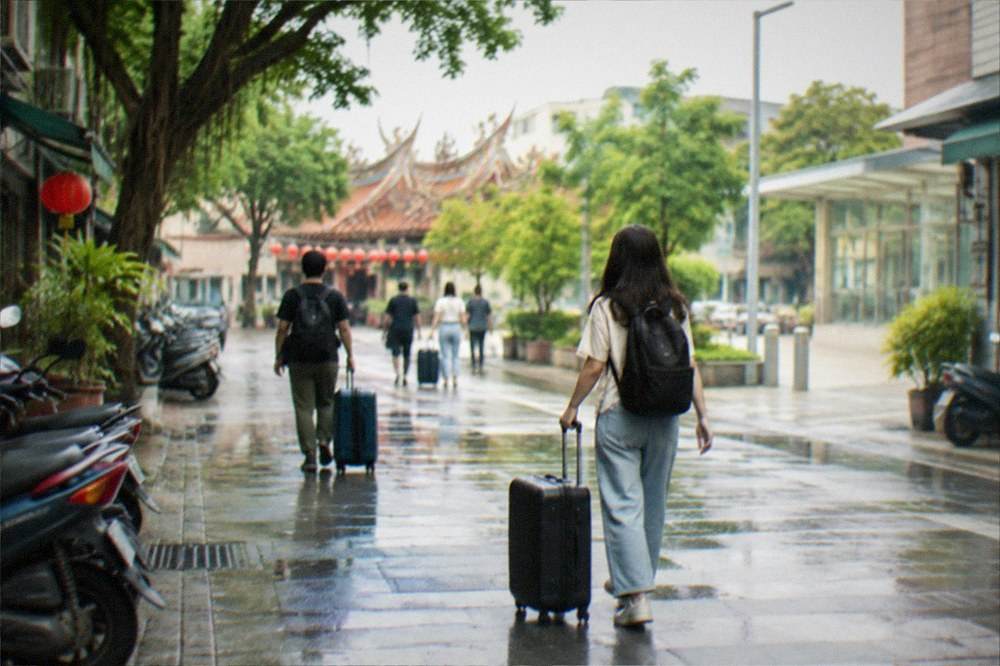 Travelers with suitcases walking through a bright rail station concourse