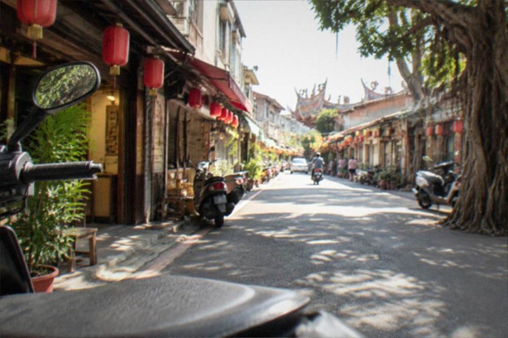 A traditional Taiwanese street lined with old shopfronts lit for the evening