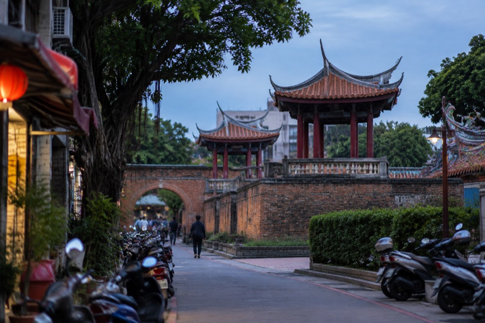 A curved brick archway and courtyard of an old Tainan temple in morning light