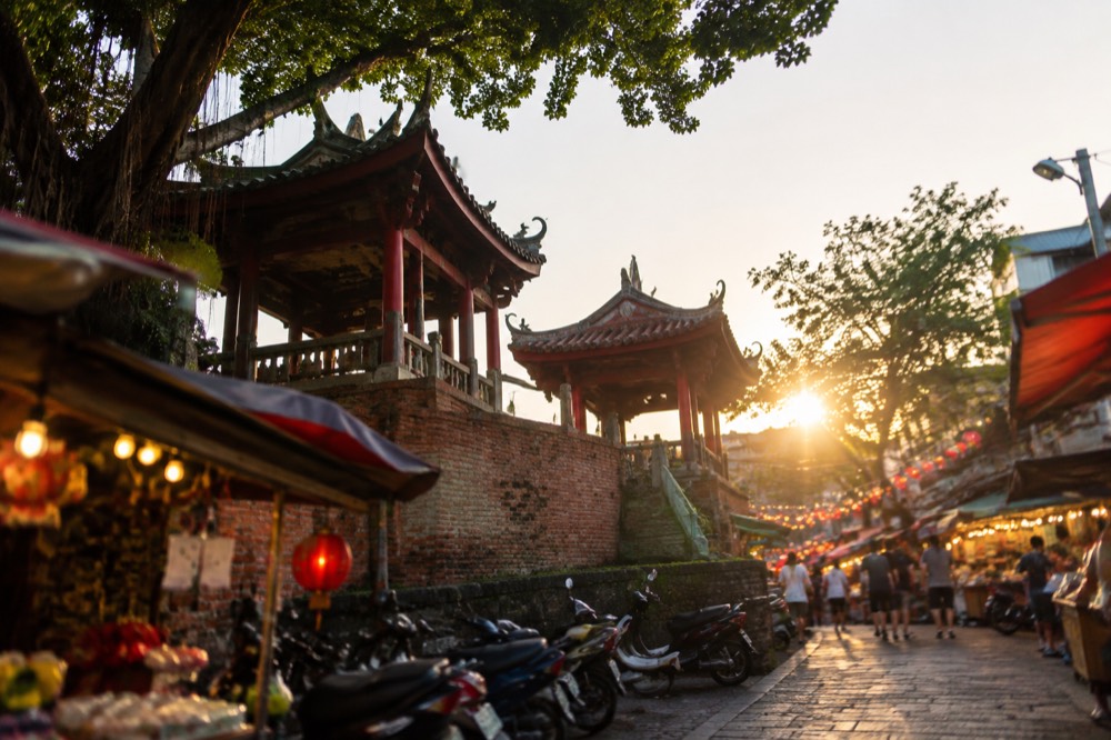 Crowded night market stalls glowing under strings of lights after dark