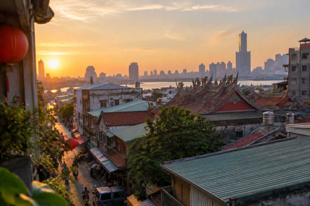 A wide view over Tainan's old city rooftops with temple roofs and a modern skyline in the distance