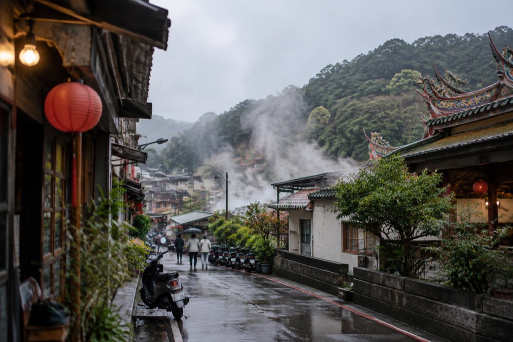 Steam rising over a tree-lined mountain road near a hot spring town in southern Taiwan