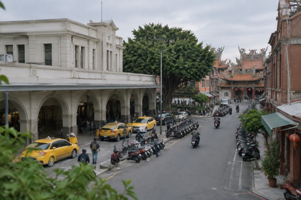 A historic Tainan street with red brick buildings and a temple gate in warm afternoon light