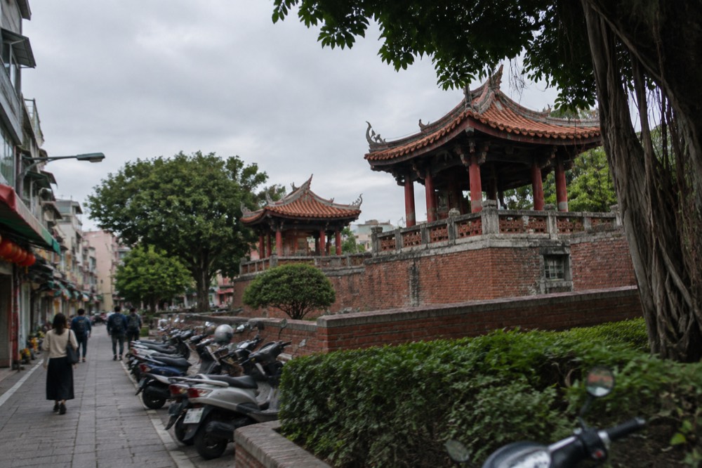 Historic red-brick tower with Chinese pavilion roofs standing in a plaza in Tainan